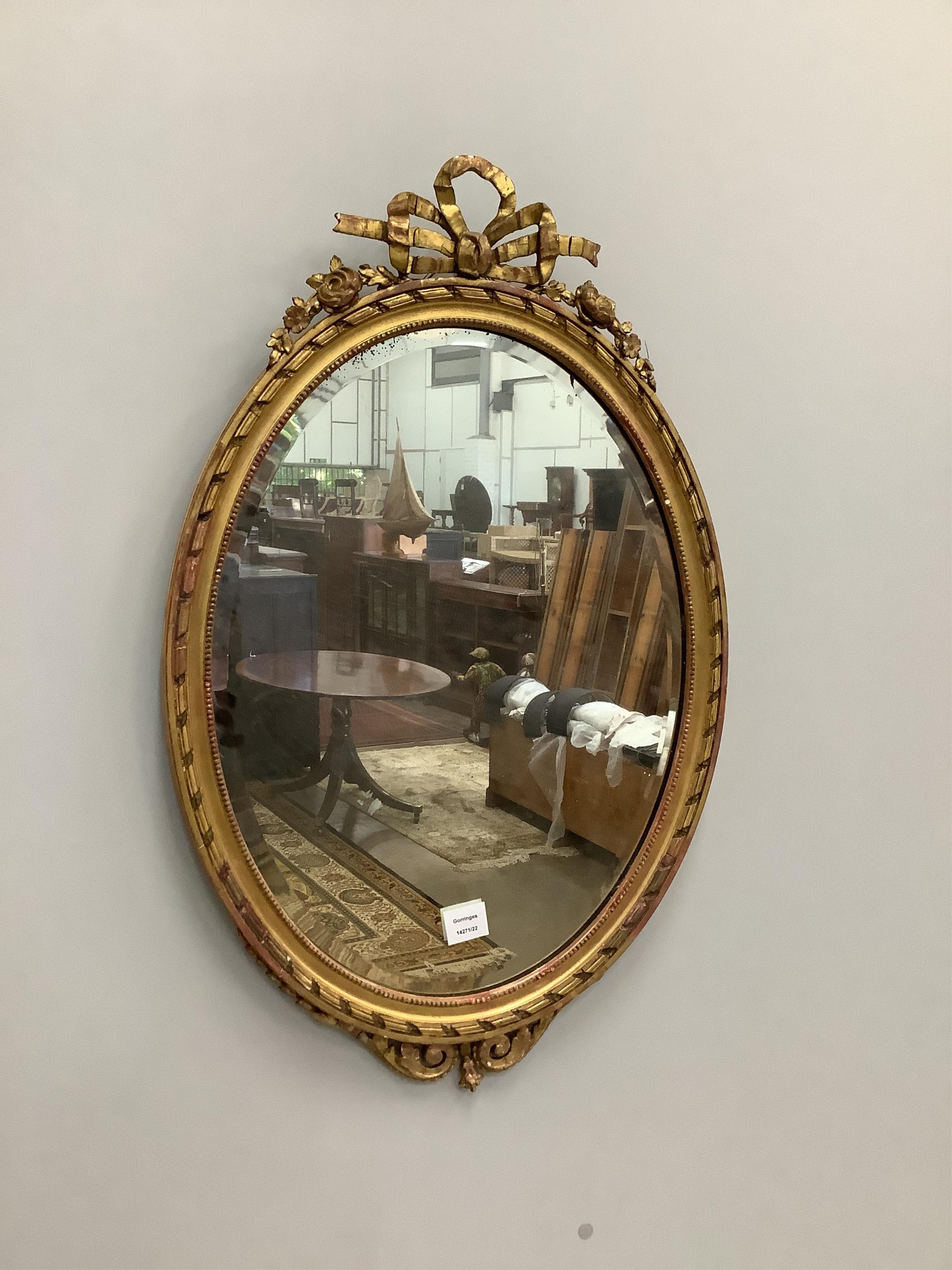 An oval giltwood composition wall mirror, width 51cm, height 80cm